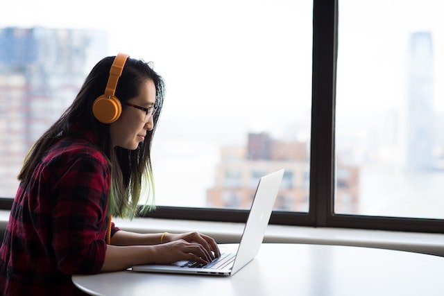 a person using a computer next to a window