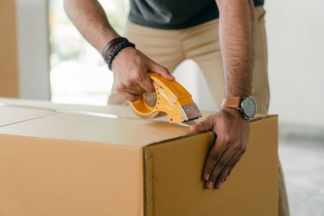 man packing moving box
